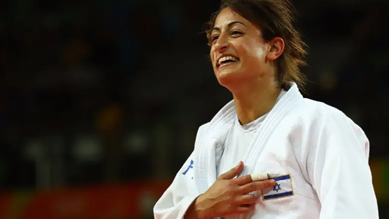 Gerbi points to the Israeli flag, moments after winning the medal
