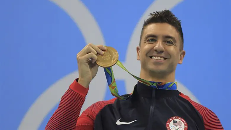 Энтони Эрвин позирует с золотой олимпийской медалью