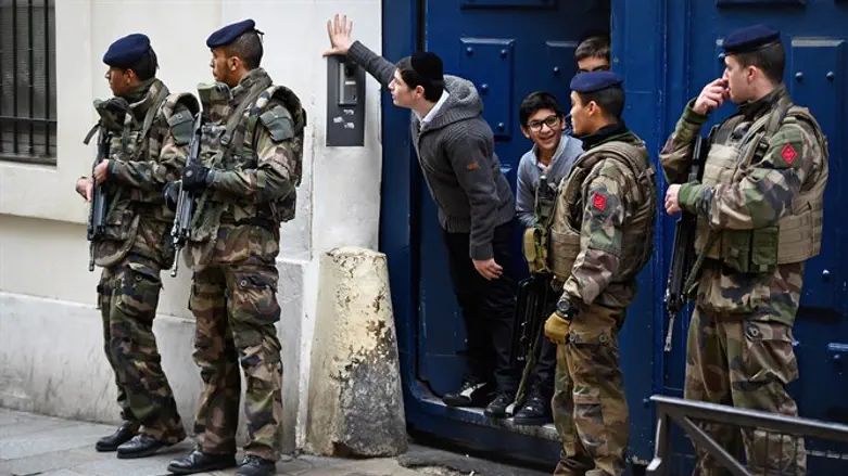 Armed soldiers patrol outside school in the Jewish quarter of the Marais district in Paris