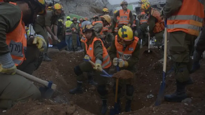 Rescue workers dig through rubble at collapsed parking garage