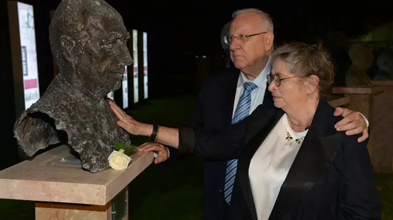 Rivlin and his wife place a flower on Peres's statue