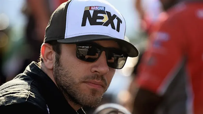 Alon Day sitting next to his car during qualifying for the NASCAR Xfinity Series’ 4th Annu