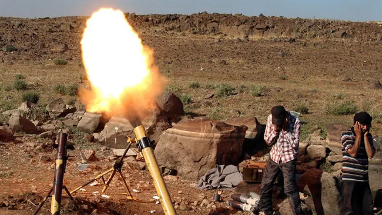 Rebel fighters fire mortar shells towards forces loyal to Syria's President Bashar al-Assa