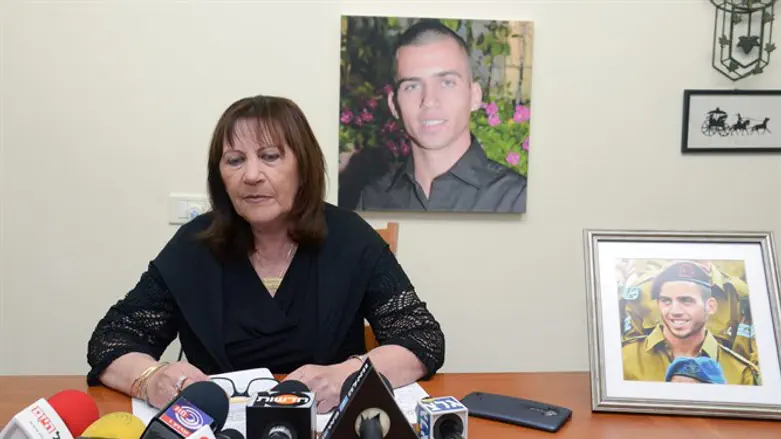 Oron Shaul's mother Zehava, in front of a picture of her son