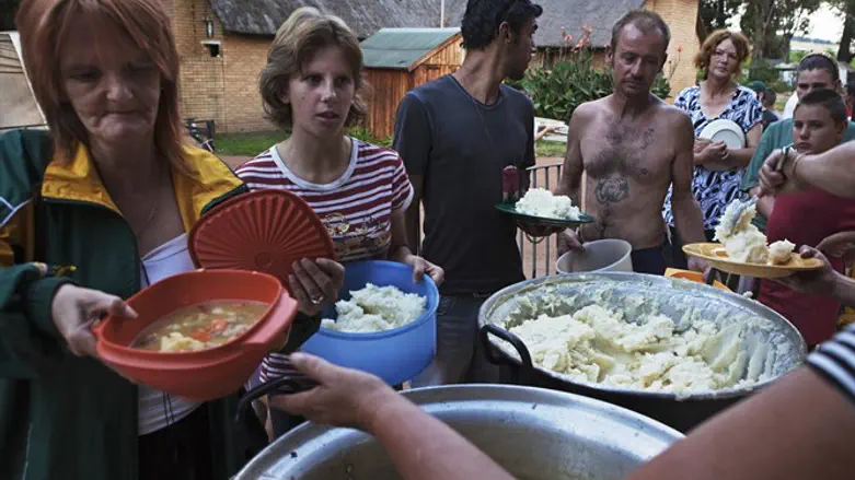 Residents of squatter camp for poor white South Africans line up for communal meal at Coro