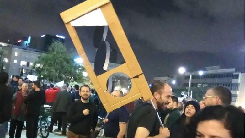Man carries mock guillotine at protest 