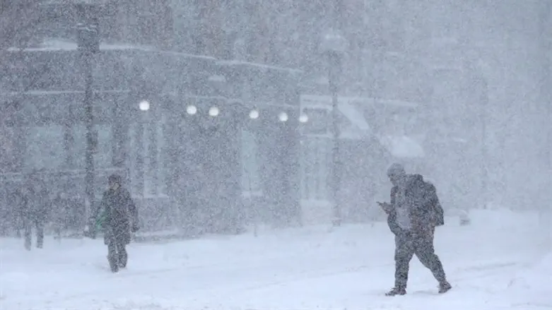 Pedestrians walking down Massachusetts Avenue during a massive winter storm in Boston, Mas