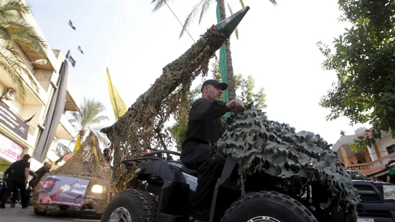 Hezbollah member drives 4-wheel motorbike mounted with mock rocket