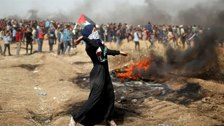 ילדה פלסטינית משליכה אבן בגבול עזה