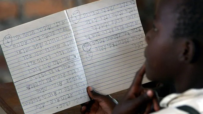 Ugandan School girl goes through Hebrew writing lesson at Hadassah Schoolh