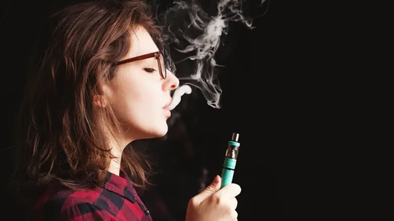 Teenage girl smokesan e-cigarette