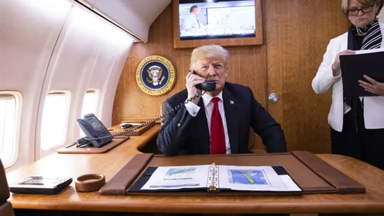 טראמפ משוחח בטלפון במטוסו