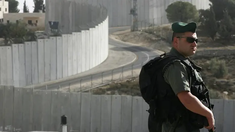 Border policeman near separation wall in Abu-Dis
