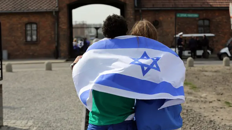 עטופים בדגל ישראל במחנה ההשמדה אושוויץ. אילוסטרציה
