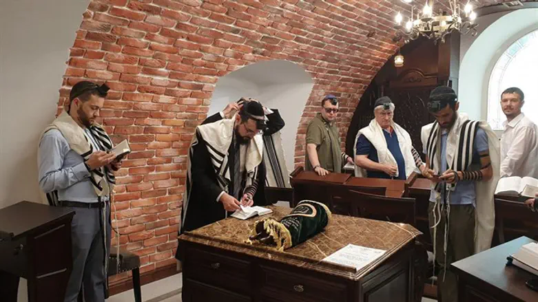 הרב שמשון איזקסון (שני מימין) מתפלל עם באי "בית-הכנסת מעץ" בקישינב