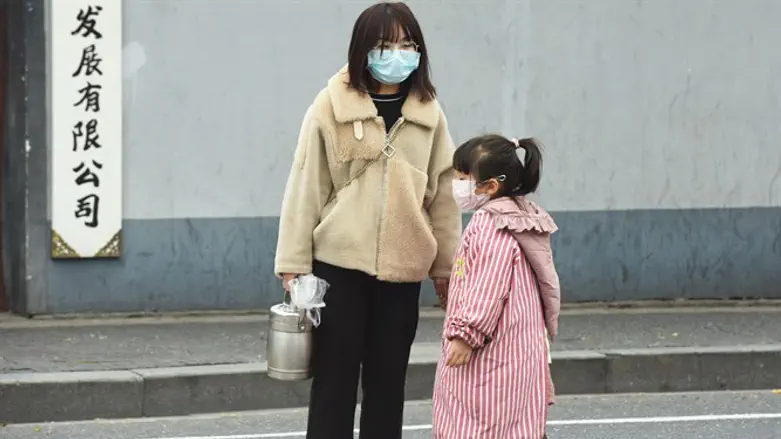 אישה וילדה עם מסכות להגנה מפני הוירוס
