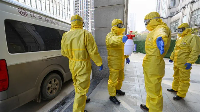 Staff at a funeral parlor wear protective suits to protect against the coronavirus.