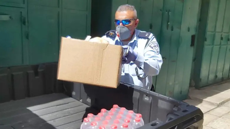 אחד השוטרים עם המזון לקשישים