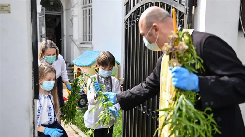A Christian Orthodox priest hands out Easter supplies in Romania