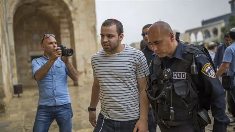 A Waqf guard (L) monitors Jewish visitors to the Temple Mount