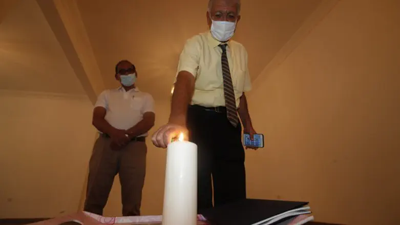 Ebrahim Nonoo lighting a candle in commemoration of Kristallnacht