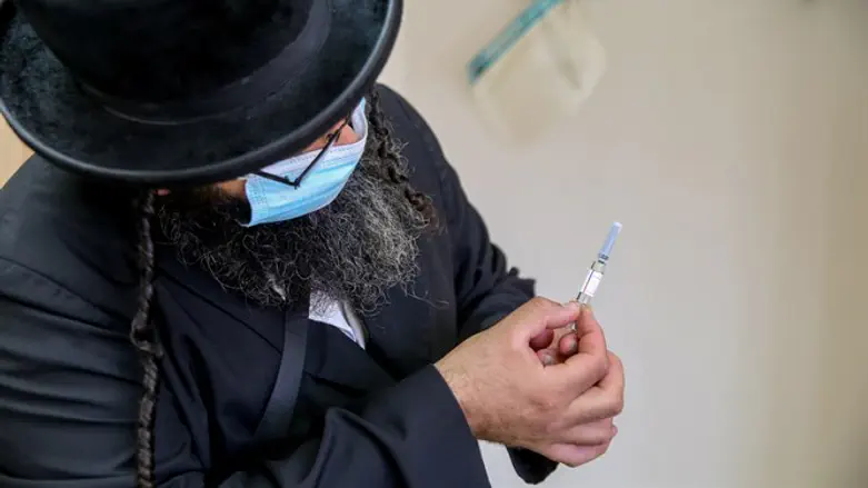Haredi man holds the Covid-19 vaccine