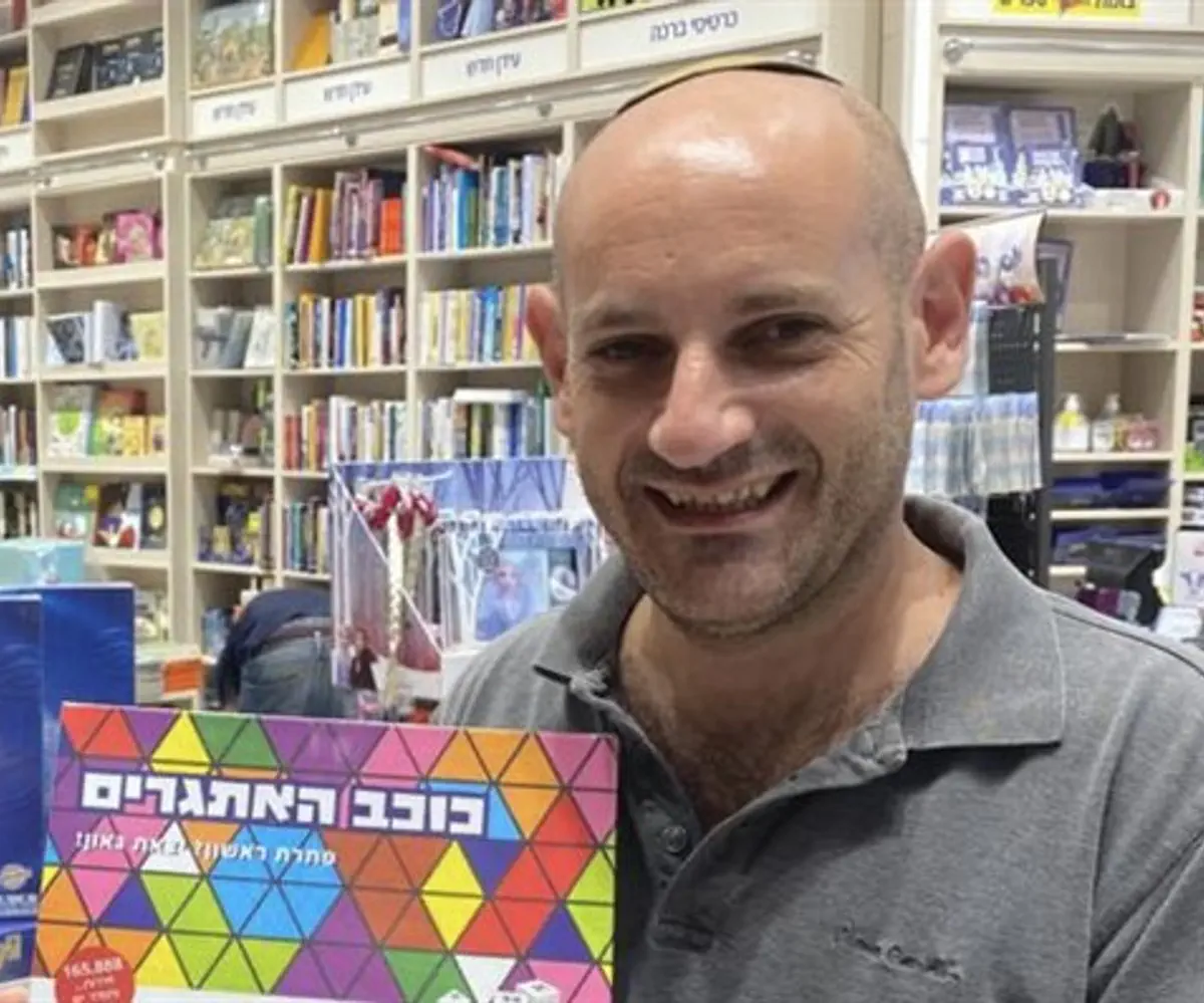 Aron Lazarus with the Hebrew version of his game, in a toy store