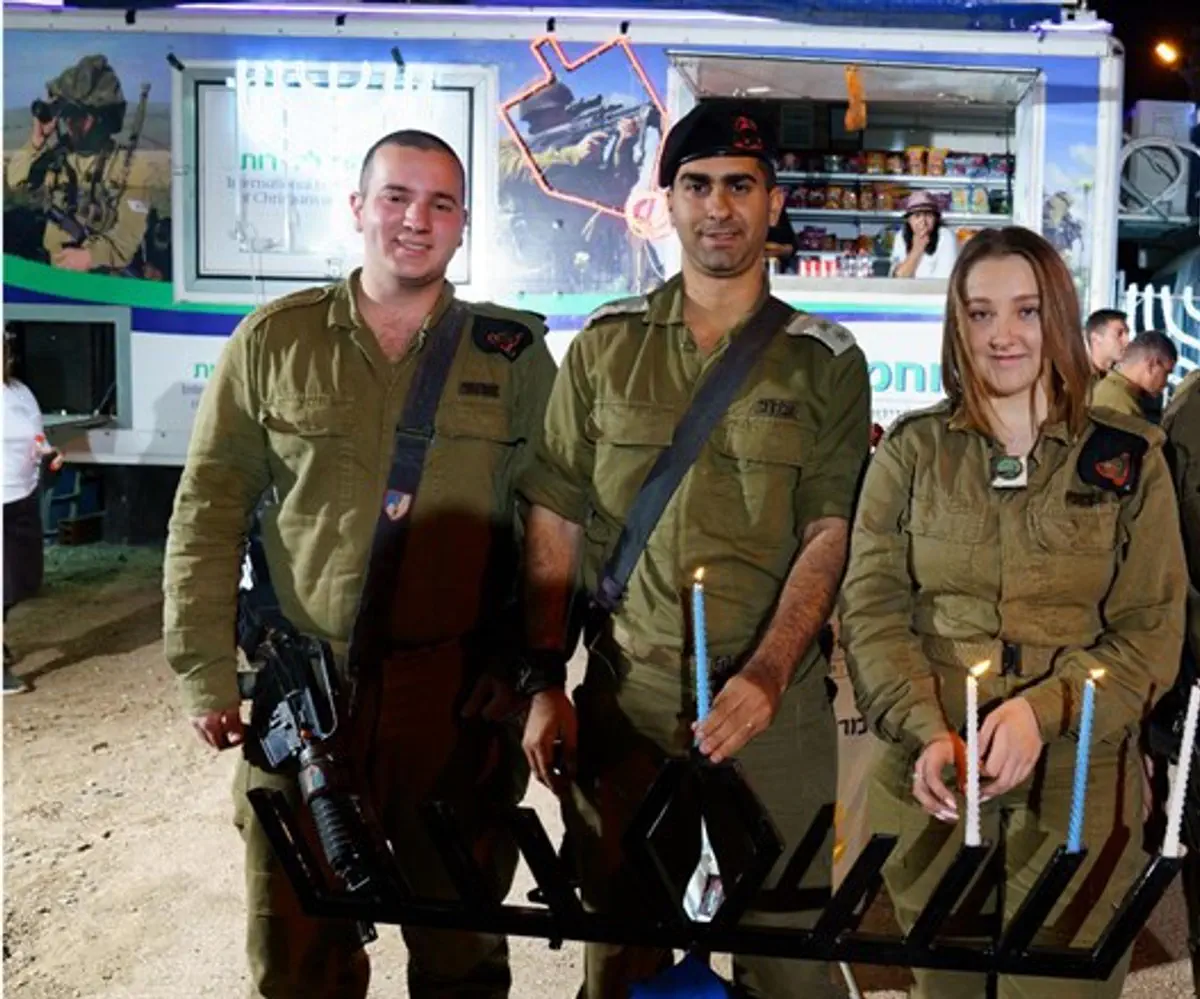 Soldiers from Sufa light candles with IFCJ IDF volunteers
