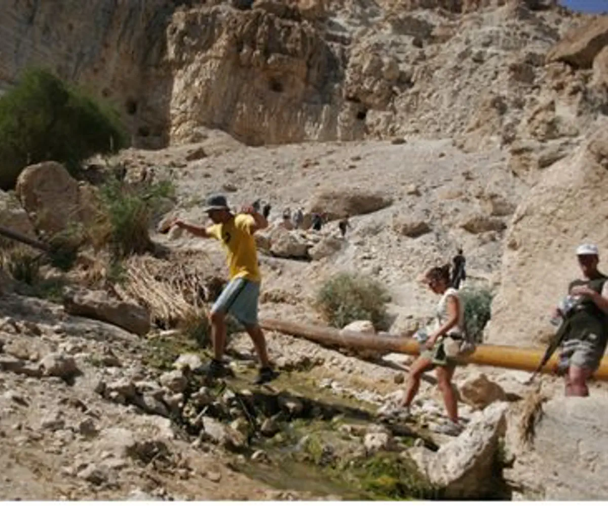 Hikers climb cliffs in Judean Desert (illus)