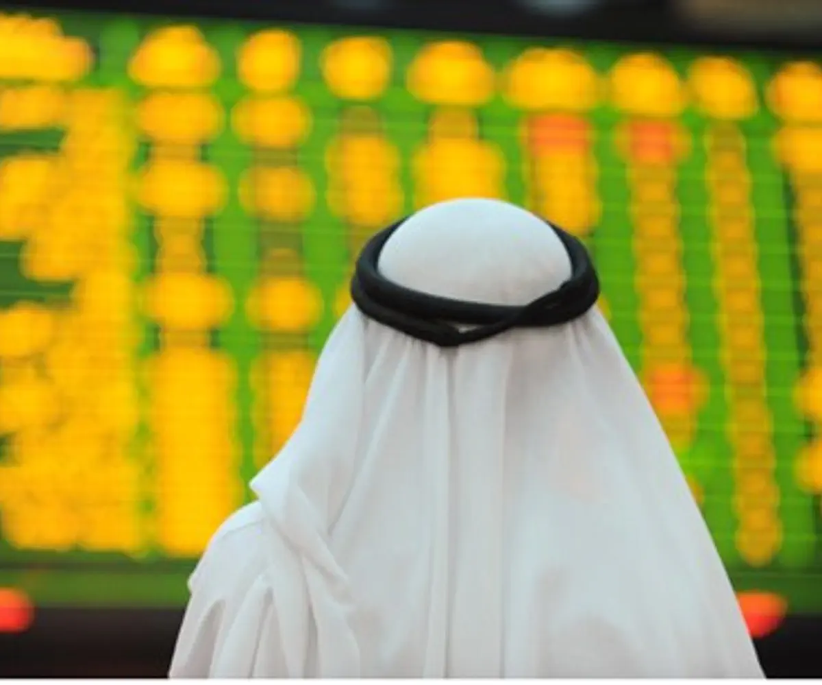 An Arab investor looks up at electronic board