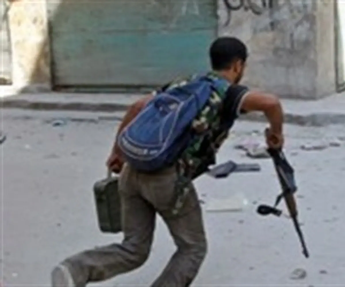  Free Syrian Army fighter runs across a stree
