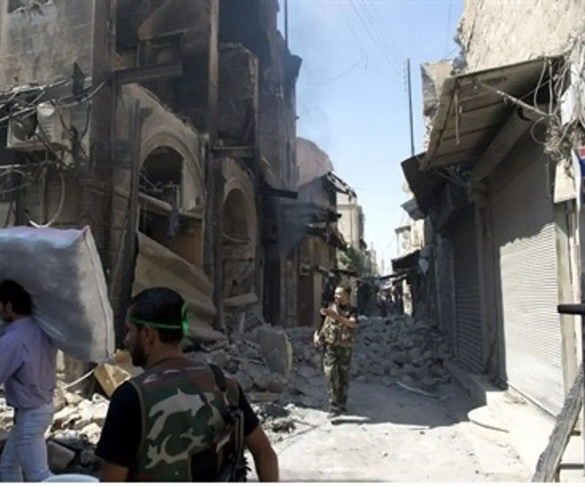 Syrian civilians walk past the rubble of buil