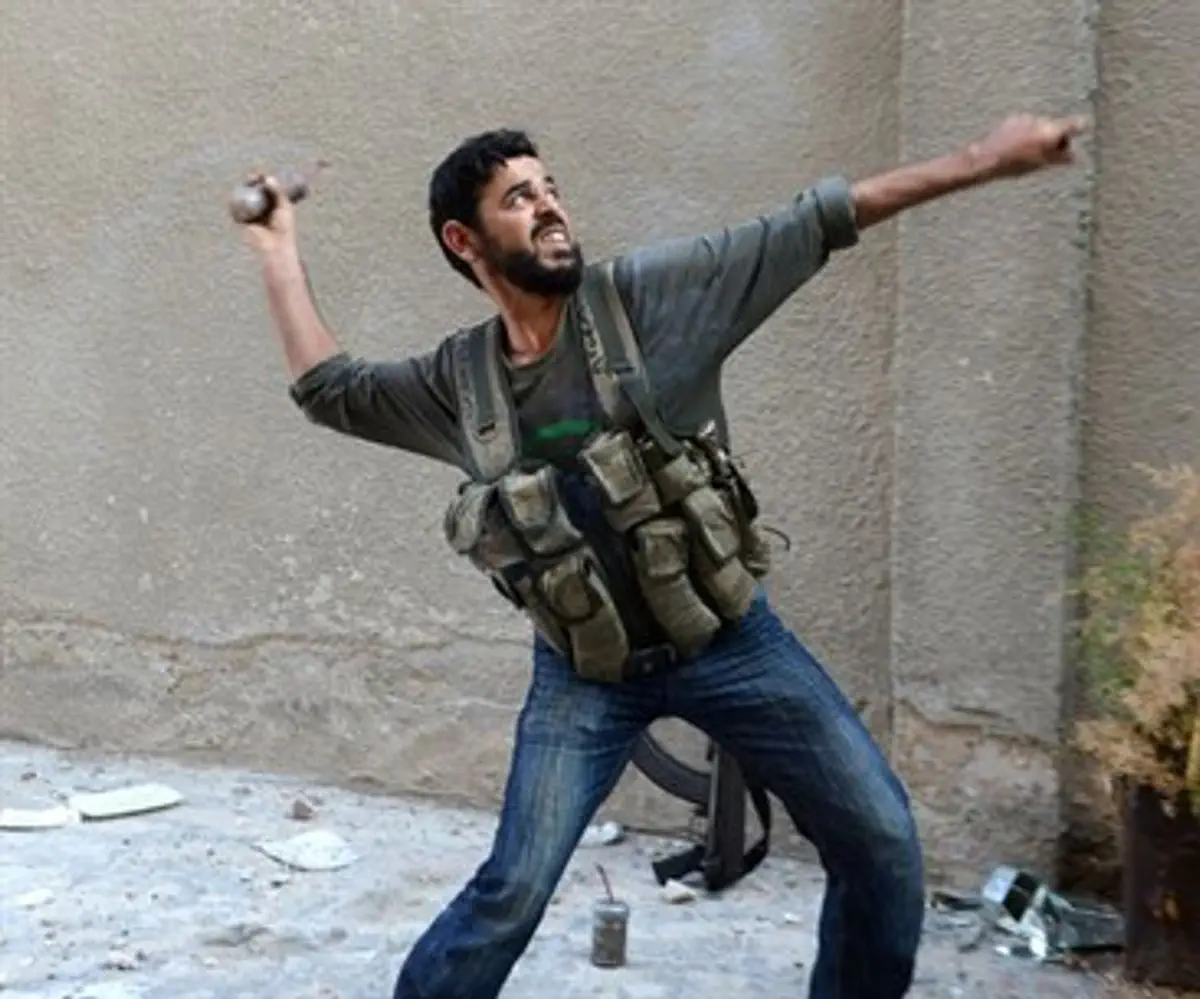 A rebel fighter throws a handmade hand grenad