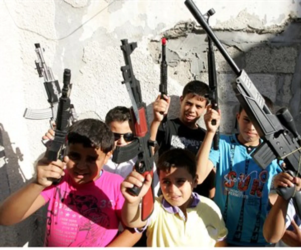 Palestinian children play with toy guns