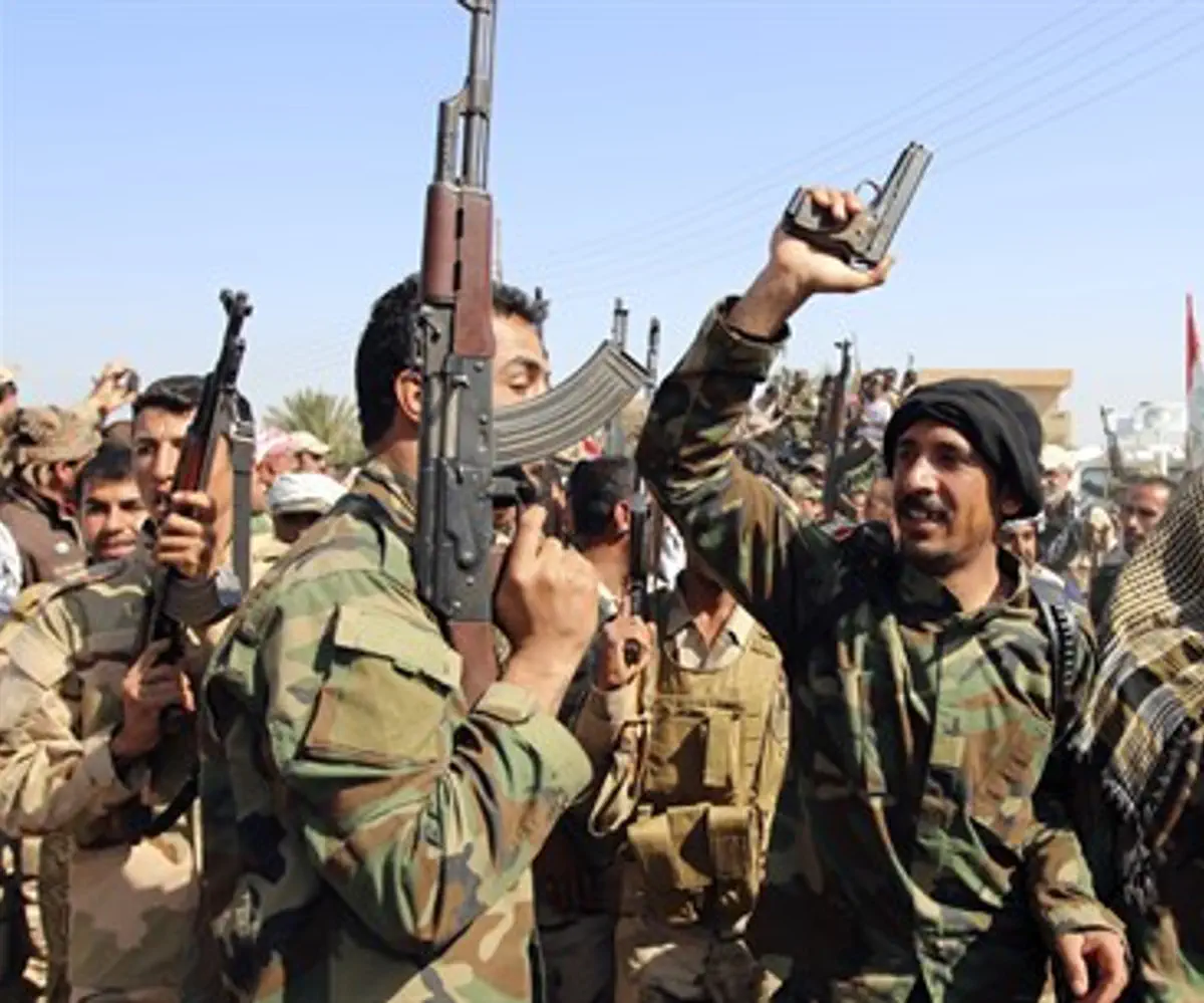 Iraqi soldiers and Shia militiamen dance outside Tikrit (file)