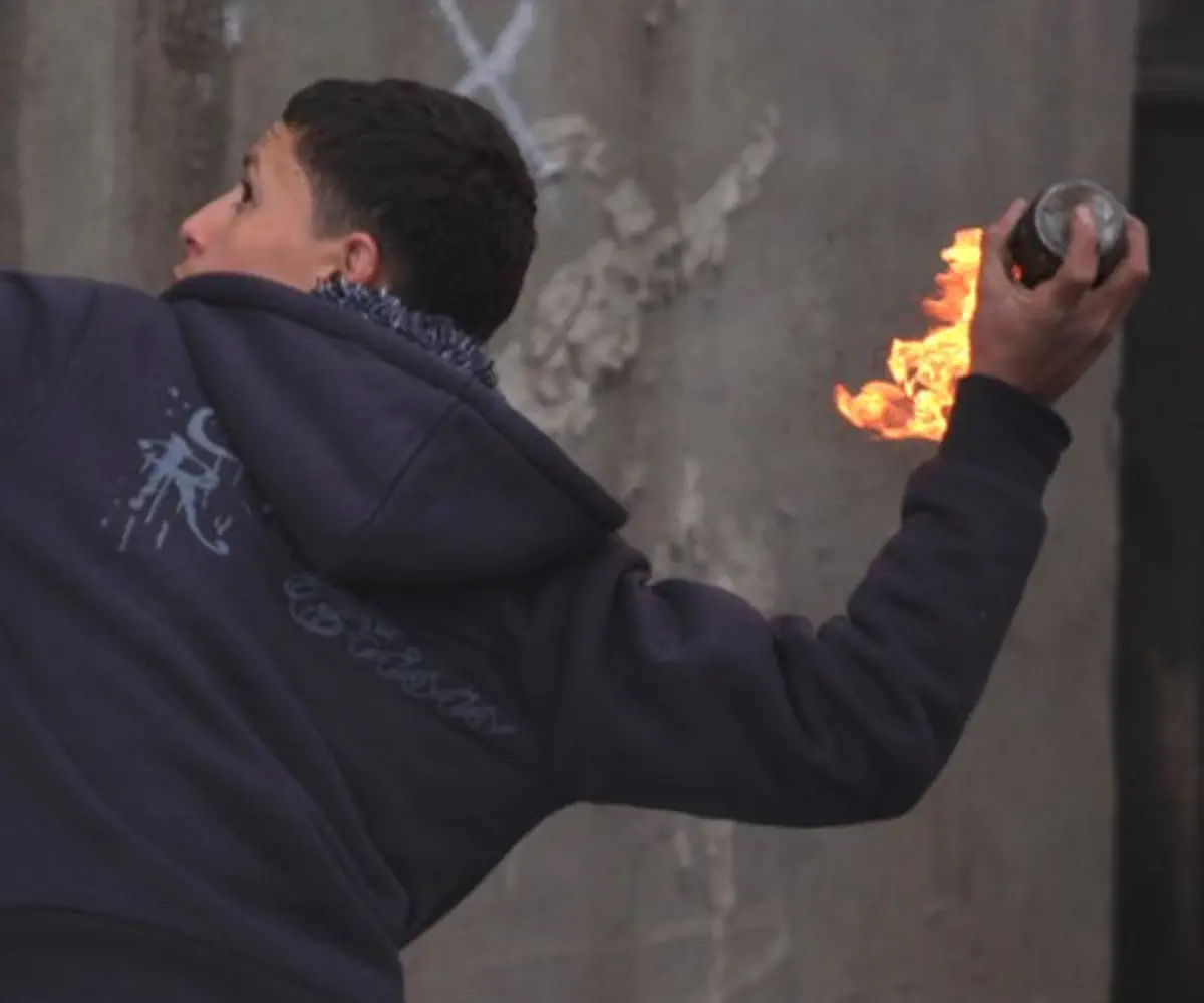Arab youth hurls a firebomb during anti-Israel riot (file)