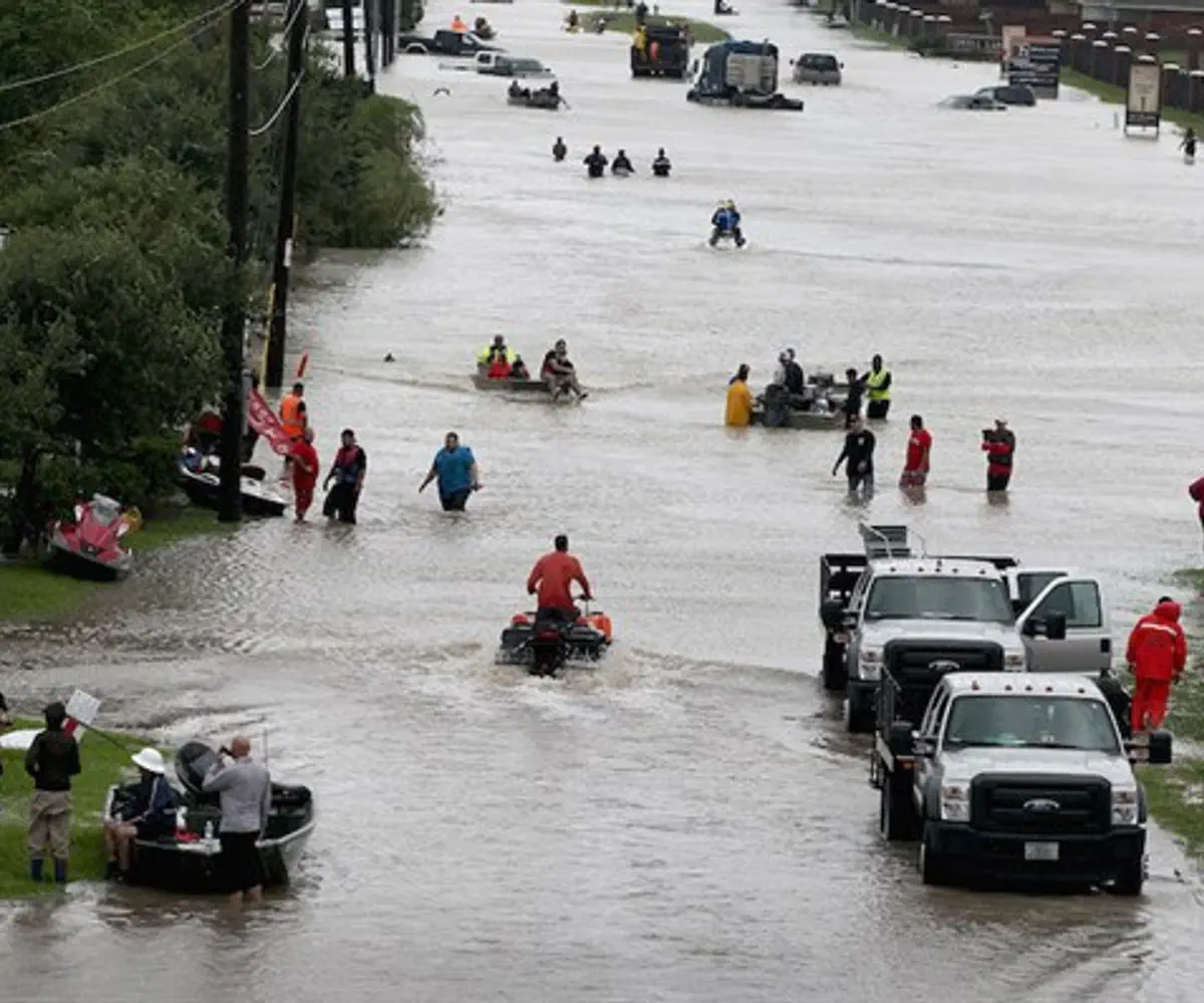 People making their way out of a neighborhood flooded by Hurricane Harvey
