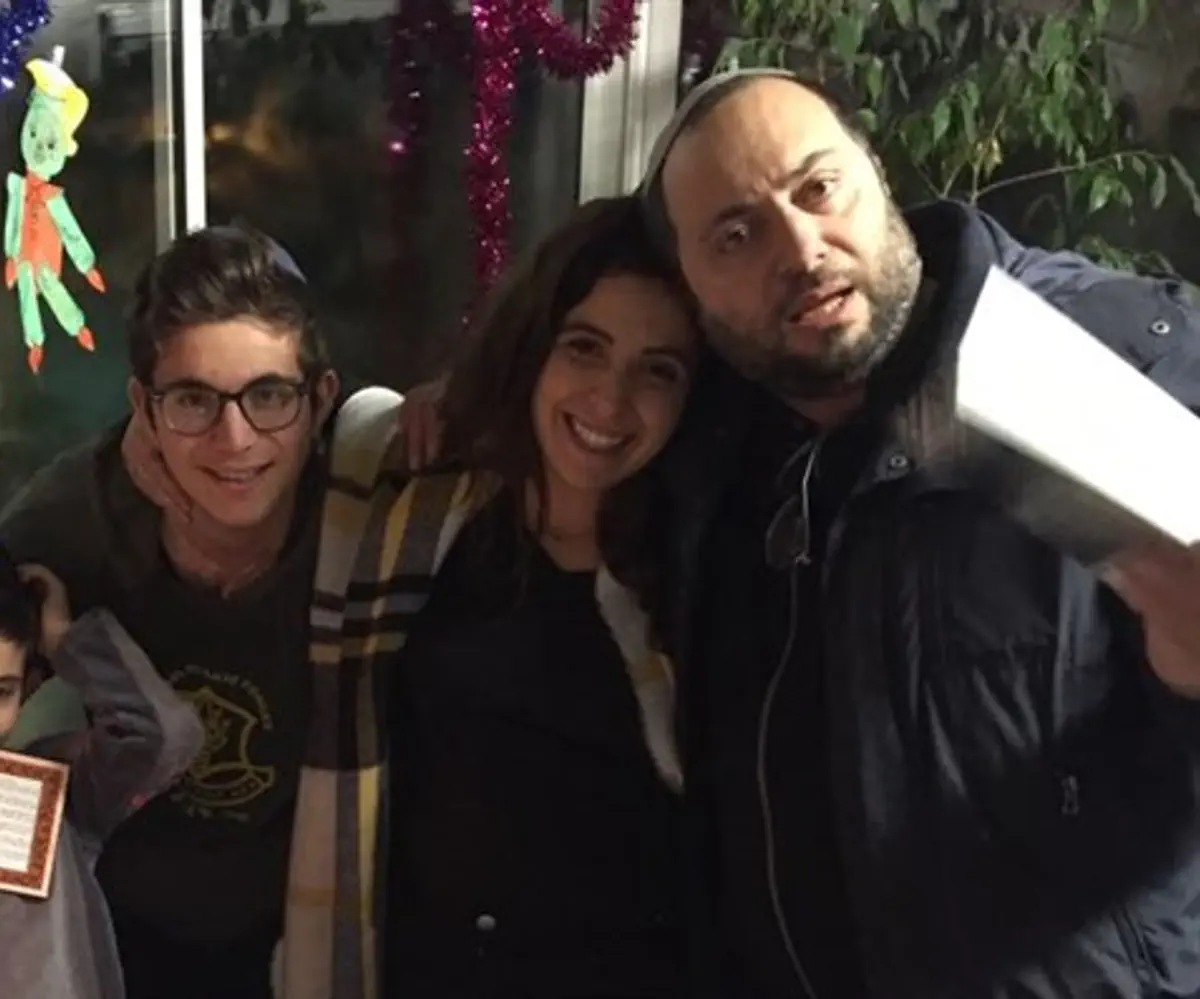 Shana Cohen lghting candles with her family in France