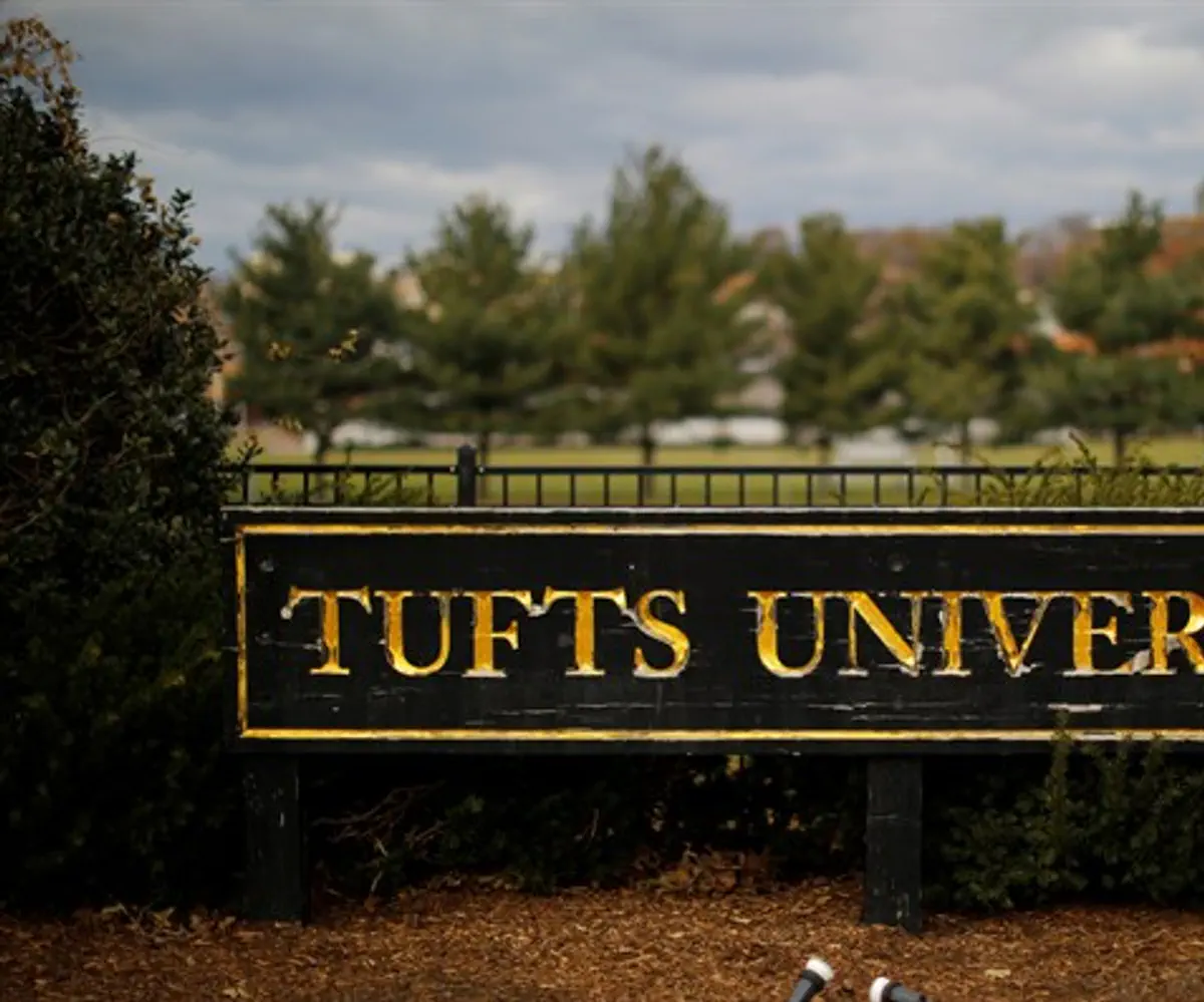 A sign stands at the edge of the campus of Tufts University in Medford