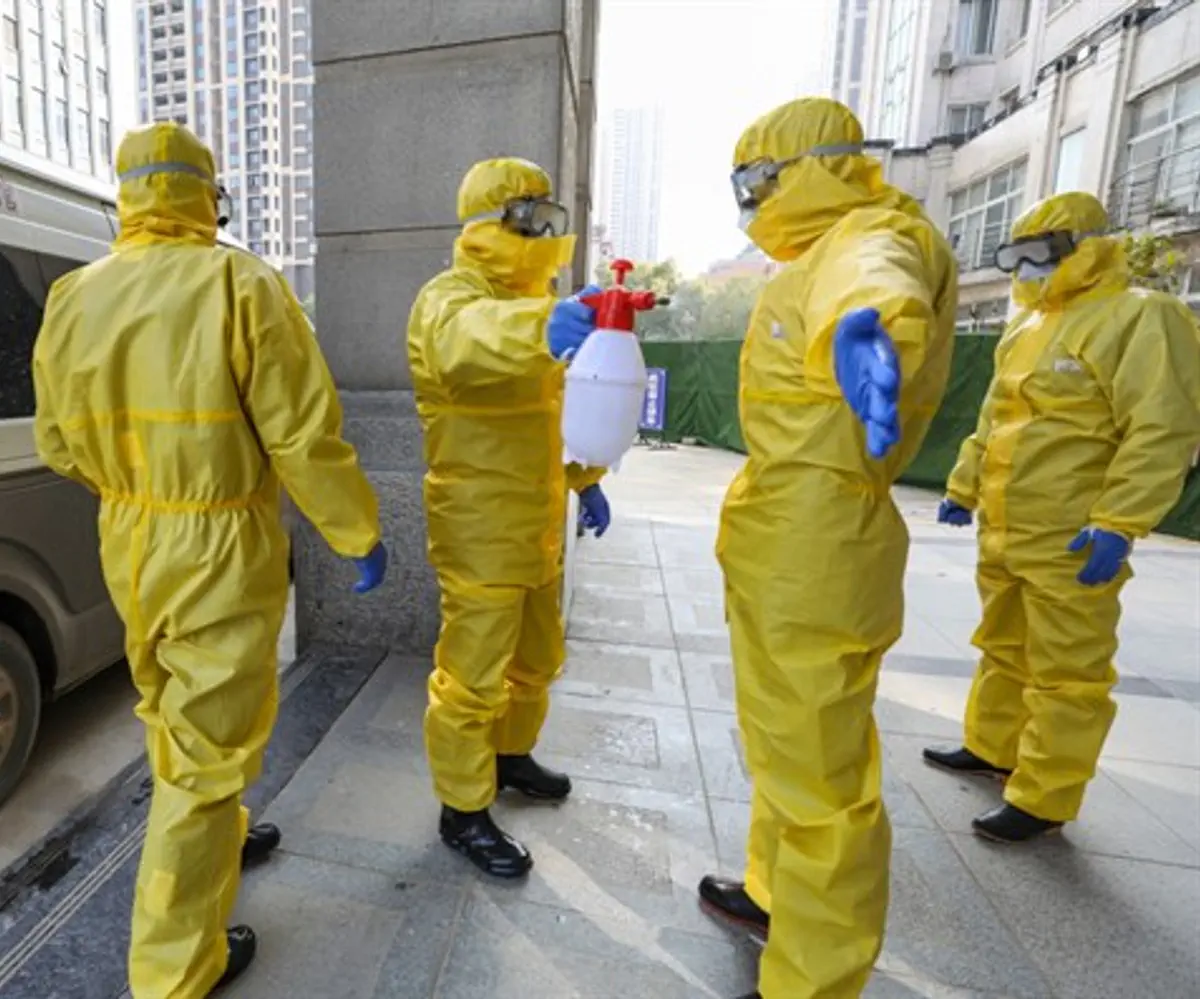 Staff at funeral parlor wear protective suits to protect against the coronavirus in Wuhan