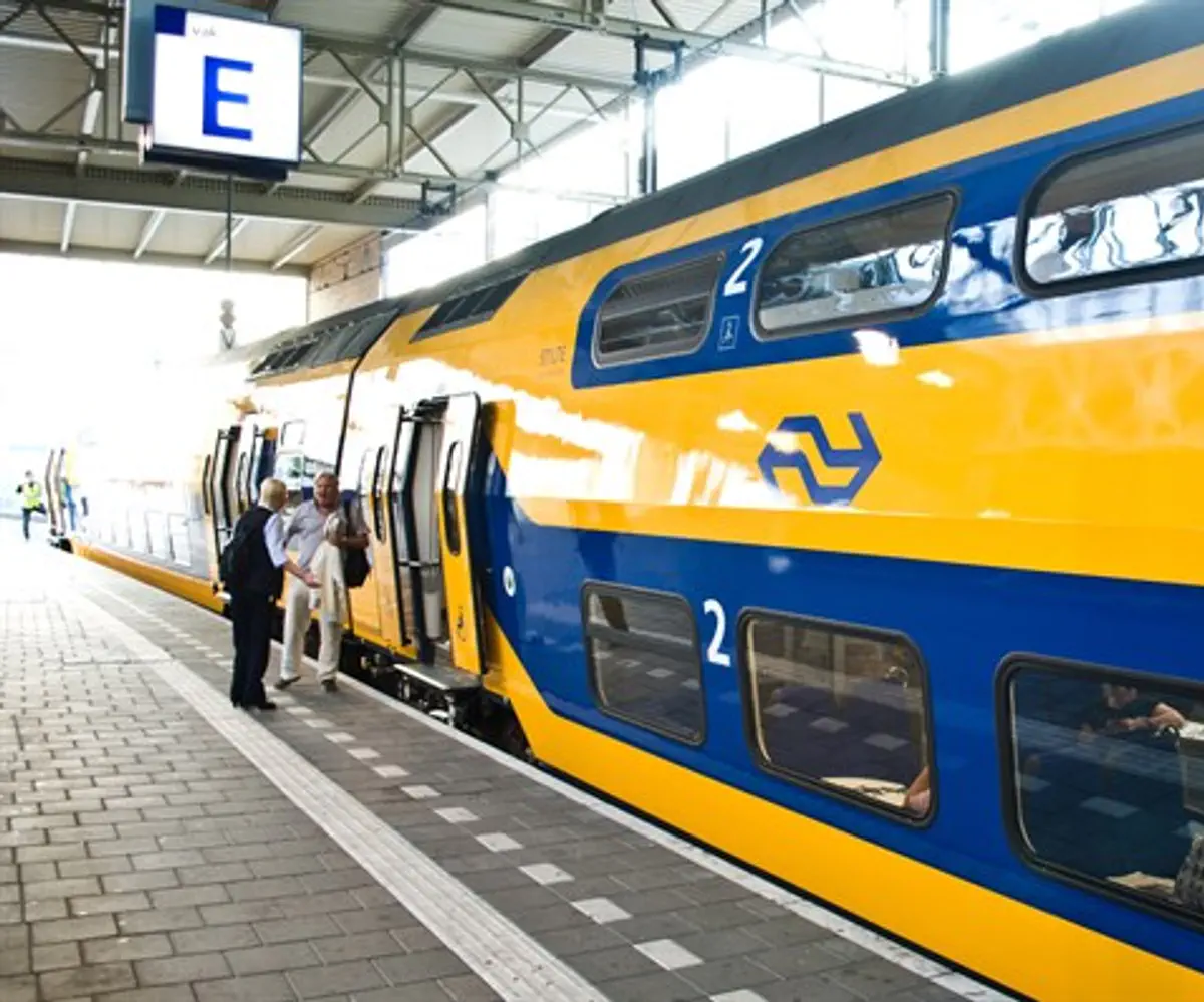 Passengers standing near a NS (Nederlandse Spoorwegen) train in the Netherlands