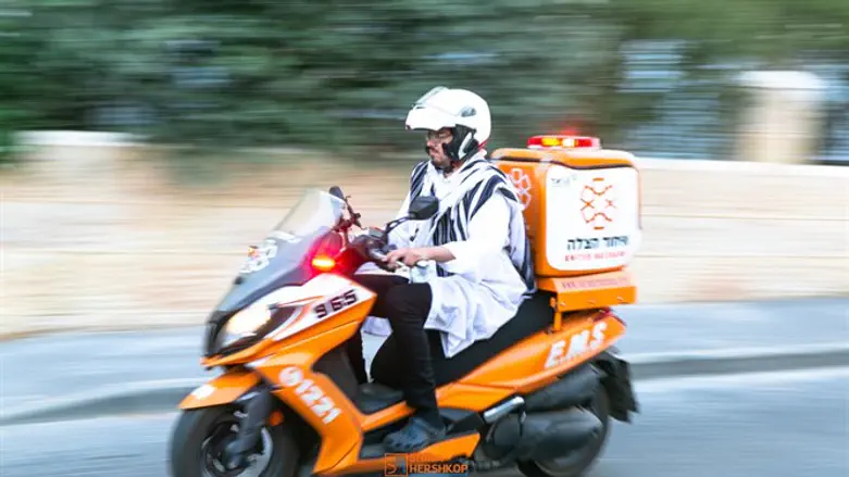 A United Hatzalah EMT riding an ambucycle wearing a kittel and tallit (illustrative)