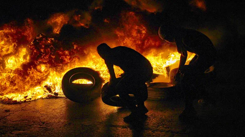 Arab rioters throw burning tires