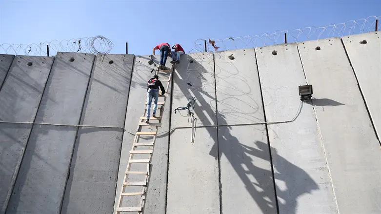 Palestinos saltan la valla cerca de Qalandiya