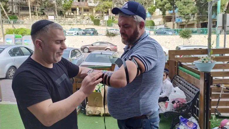 Helping an immigrant put on Tefillin