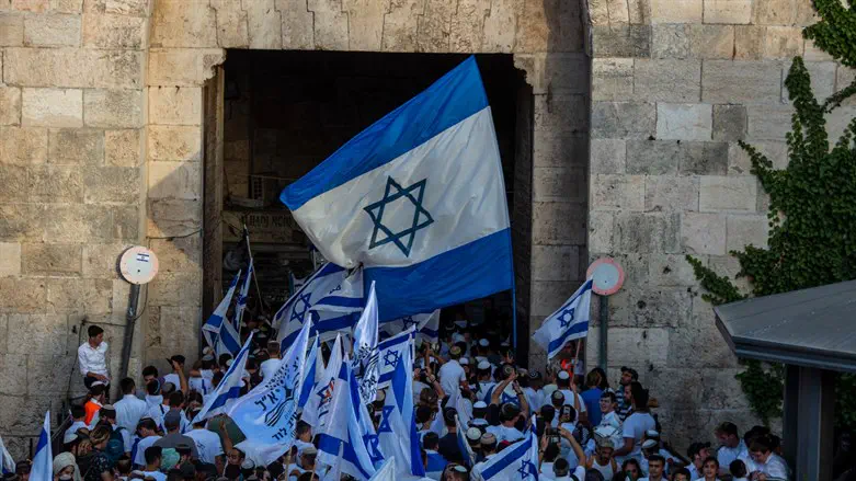 Israelis march flags through the Damascus Gate in Jerusalem