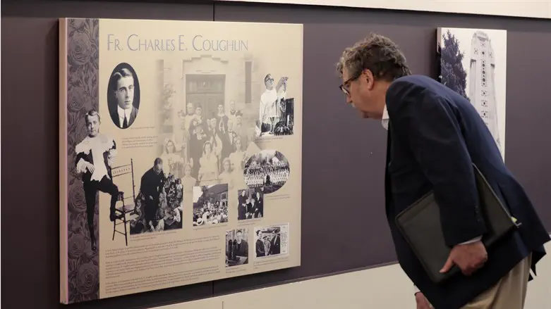 Levi Smith inspects a plaque discussing the history of Father Charles Coughlin