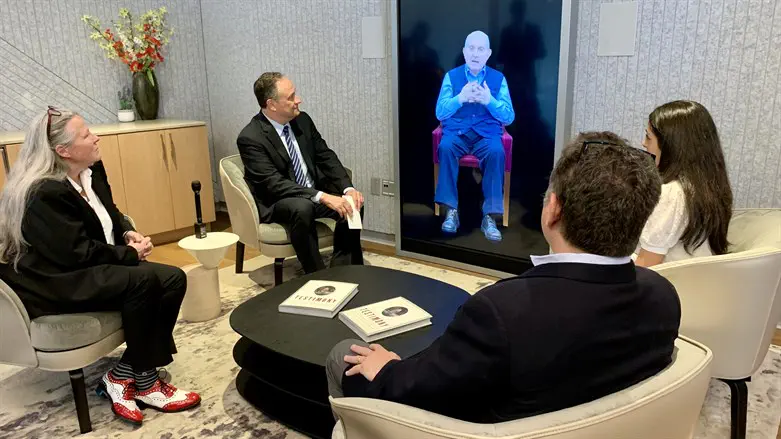 Doug Emhoff, second from left, speaks to an interactive AI video of Pinchas Gutter.
