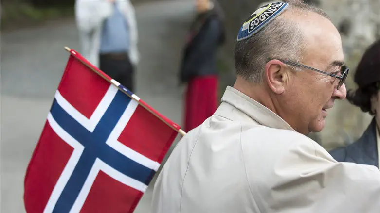 Jewish man wearing a kippah holds a Norwegian flag on Constitution Day in Oslo