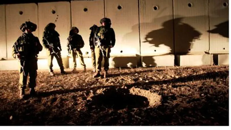IDF troops view crater created by shell
